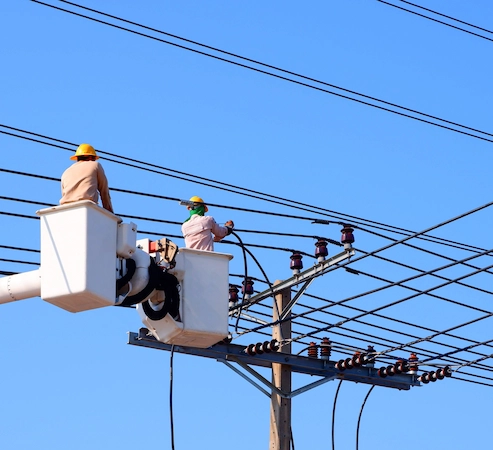 Technicians fixing utility poles
